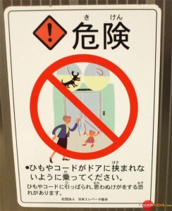 A Japanese sign on an elevator urging people to make sure they don't get any straps/cords stuck in the doors.